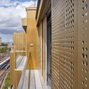 Perforated sliding panels animate the facade of Faraday House